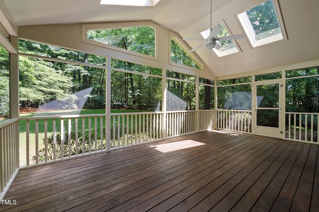 unfurnished sunroom with a skylight, vaulted ceiling, ceiling fan, and plenty of natural light