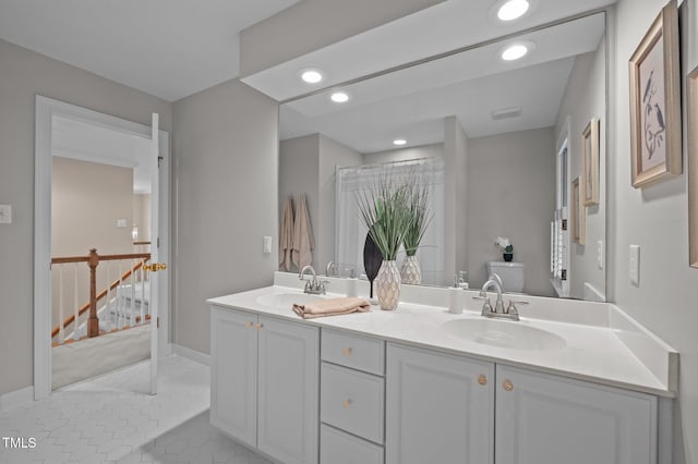 bathroom with recessed lighting, double vanity, baseboards, and tile patterned flooring