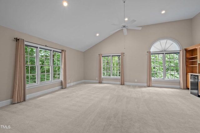 unfurnished living room with light carpet, baseboards, plenty of natural light, high vaulted ceiling, and recessed lighting