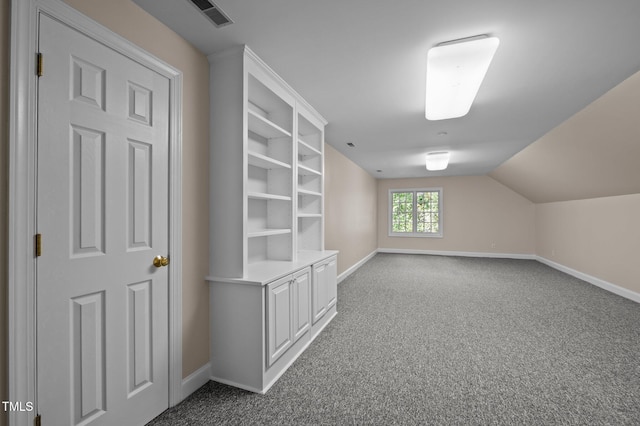 bonus room featuring baseboards, dark carpet, and vaulted ceiling