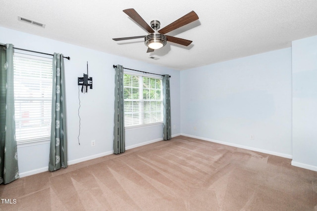 empty room with light colored carpet, ceiling fan, and baseboards