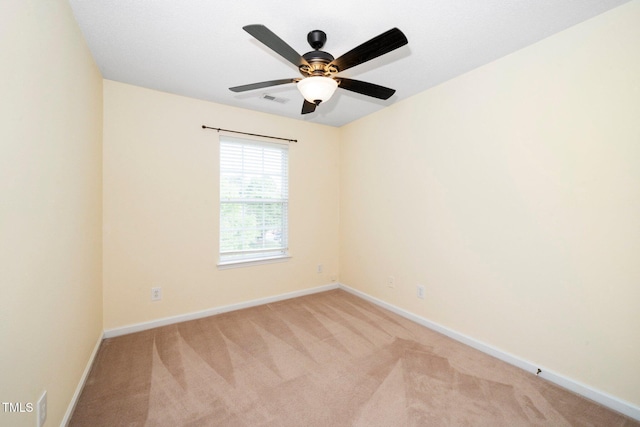 unfurnished room with light colored carpet, baseboards, and ceiling fan