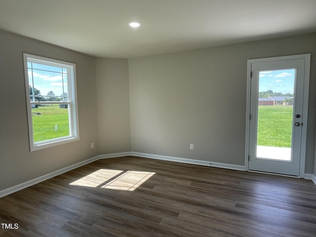 unfurnished room featuring baseboards, dark wood finished floors, and recessed lighting