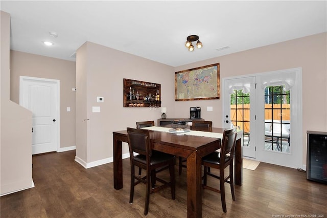 dining area featuring beverage cooler, wood finished floors, and baseboards