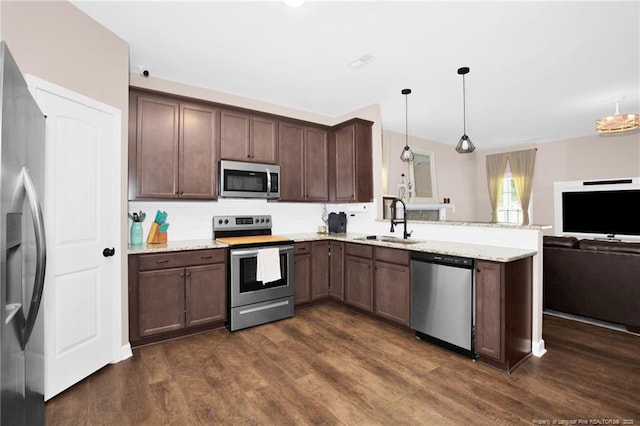 kitchen with a sink, open floor plan, a peninsula, appliances with stainless steel finishes, and dark wood-style floors