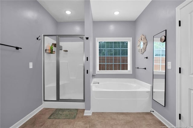 full bath featuring tile patterned floors, a bath, baseboards, and a shower stall