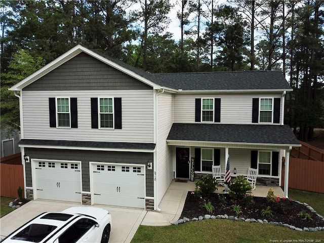 traditional-style home with covered porch, stone siding, a garage, fence, and concrete driveway