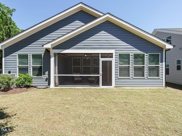 rear view of house with a sunroom and a lawn