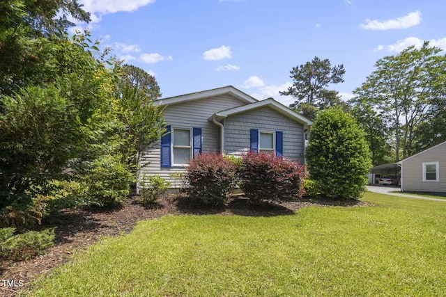 view of front of house featuring a detached carport and a front yard