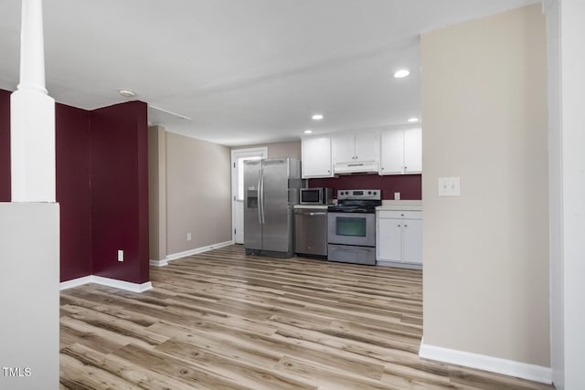 kitchen featuring appliances with stainless steel finishes, under cabinet range hood, baseboards, white cabinetry, and recessed lighting