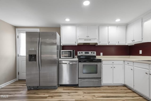 kitchen with appliances with stainless steel finishes, under cabinet range hood, white cabinets, and recessed lighting