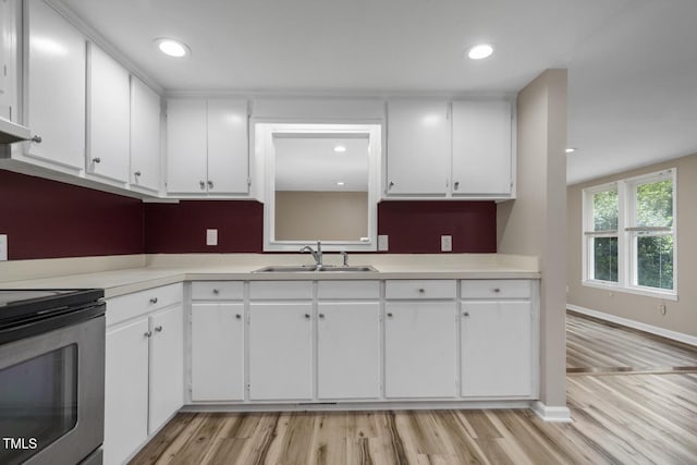 kitchen featuring a sink, electric range, white cabinetry, light wood-type flooring, and recessed lighting