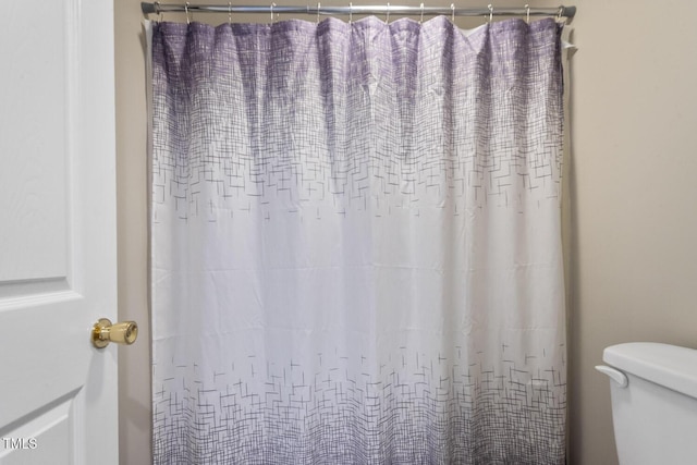 full bath featuring toilet and a shower with shower curtain