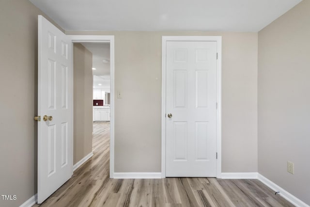 unfurnished bedroom featuring light wood-style floors and baseboards