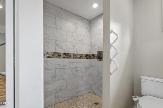 bathroom featuring a tile shower, toilet, and recessed lighting