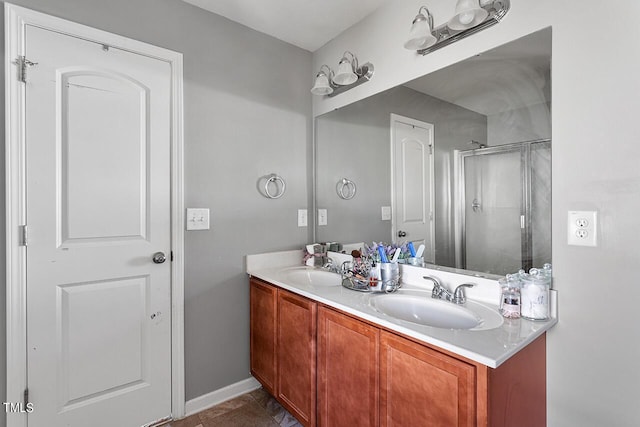 bathroom with a shower stall, double vanity, tile patterned floors, and baseboards