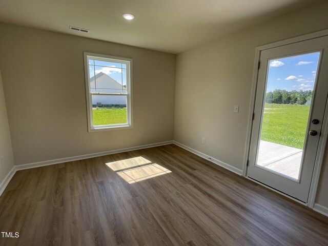 unfurnished room with baseboards, dark wood-style flooring, recessed lighting, and visible vents