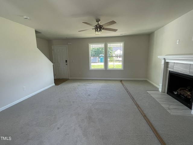 unfurnished living room with carpet, baseboards, a ceiling fan, and a fireplace