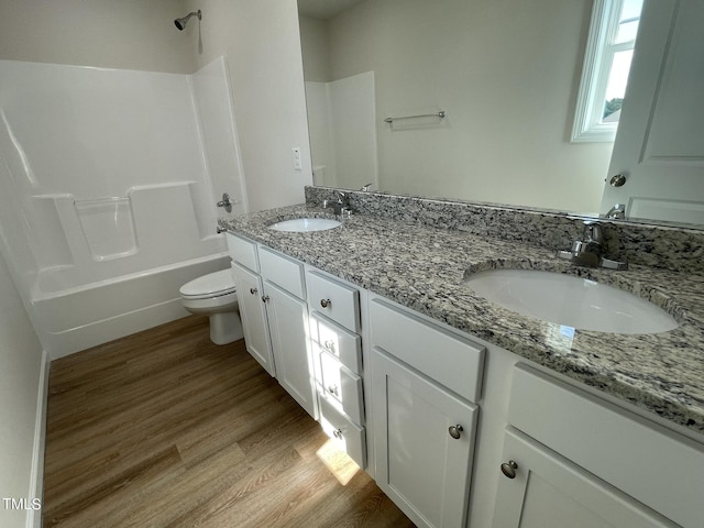 bathroom featuring toilet, a sink, and wood finished floors