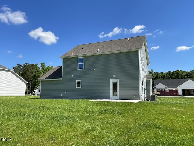 rear view of property featuring a yard and central AC unit