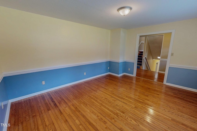 unfurnished room with wood finished floors and baseboards