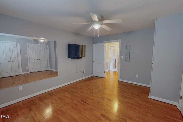 unfurnished room featuring ceiling fan, wood finished floors, and baseboards