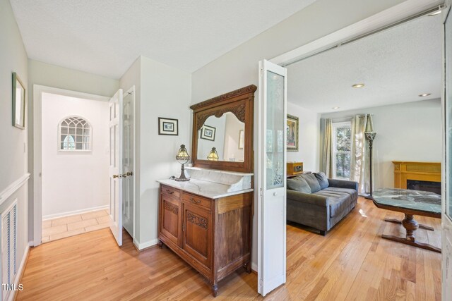 hall featuring light wood finished floors and baseboards