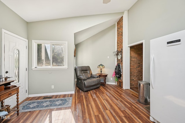 entryway with wood finished floors, baseboards, and lofted ceiling