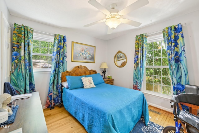 bedroom featuring wood finished floors, baseboards, and ceiling fan