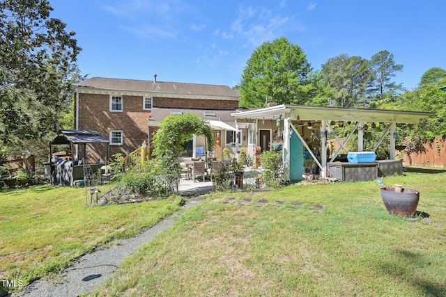 rear view of house with a patio, a lawn, a gazebo, and brick siding
