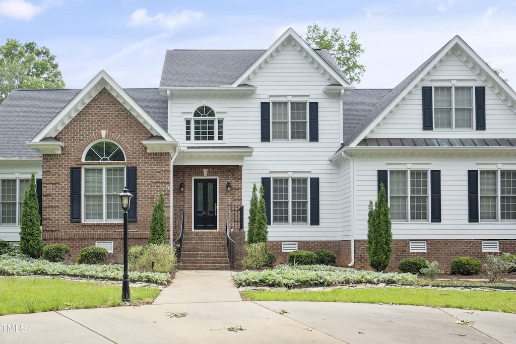 4812 Cornoustie Ct, Holly Springs, NC 27540 - view of front facade with a standing seam roof, roof with shingles, and brick siding