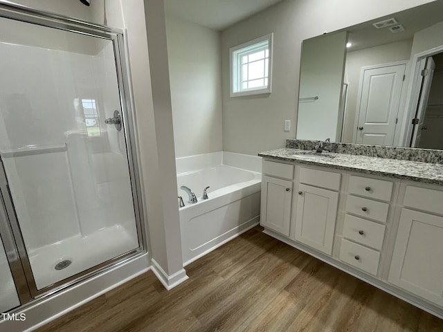 167 Lotus Ave, Smithfield, NC 27577 - bathroom with vanity, a garden tub, a shower stall, and wood finished floors