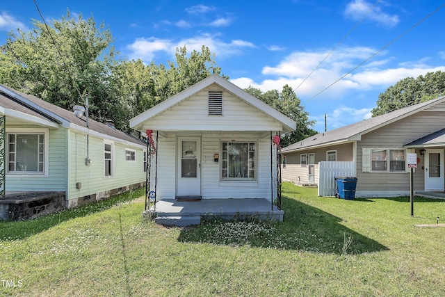 shotgun-style home featuring a porch and a front yard