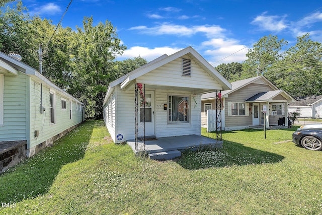 shotgun-style home with covered porch and a front yard