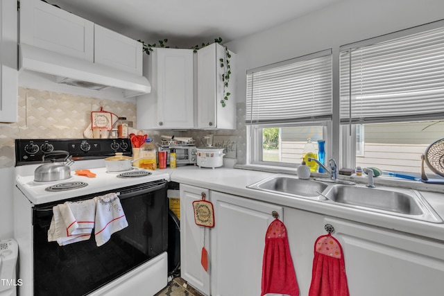 kitchen with range with electric cooktop, white cabinets, a sink, light countertops, and backsplash