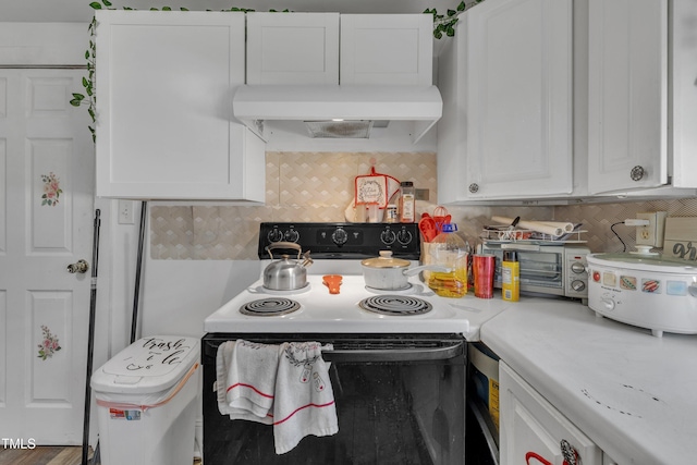 kitchen with range with electric stovetop, white cabinets, under cabinet range hood, light countertops, and decorative backsplash
