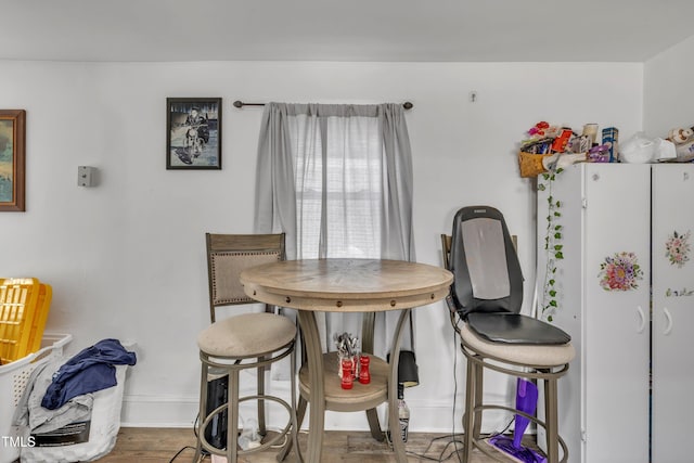 dining space featuring baseboards and wood finished floors