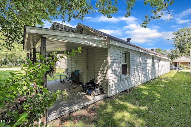 view of side of property featuring a yard and a patio area