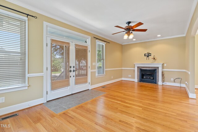 207 N Hopkins Ave, Spring Hope, NC 27882 - unfurnished living room featuring wood finished floors, french doors, a ceiling fan, a fireplace, and ornamental molding