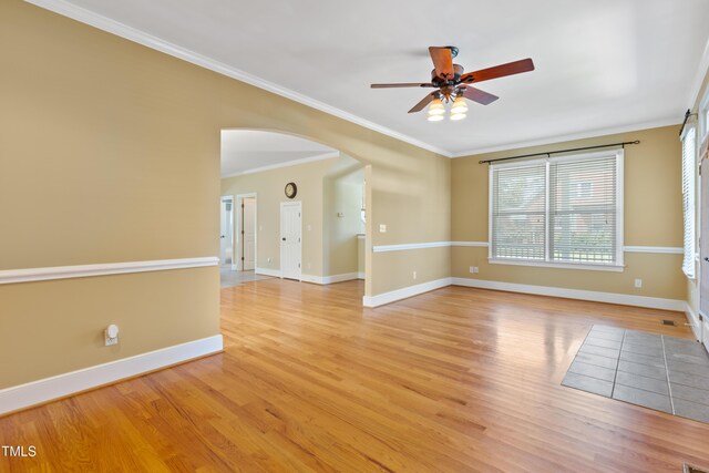 207 N Hopkins Ave, Spring Hope, NC 27882 - spare room featuring ceiling fan, arched walkways, light wood-style floors, baseboards, and crown molding