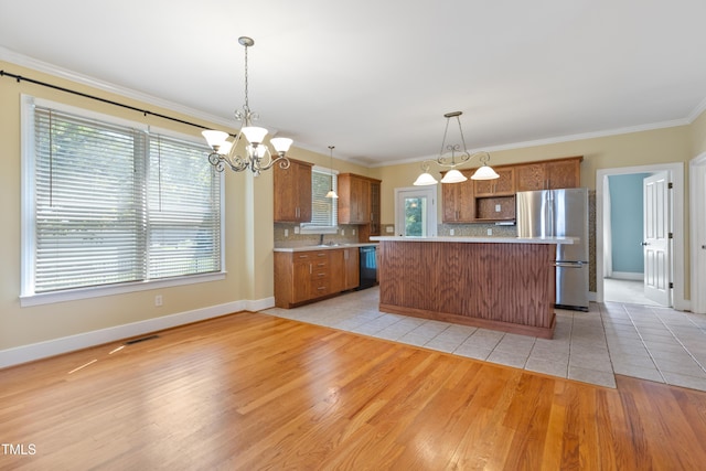 207 N Hopkins Ave, Spring Hope, NC 27882 - kitchen with freestanding refrigerator, dishwasher, brown cabinets, decorative backsplash, and light countertops