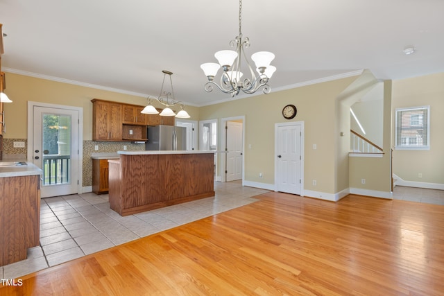 207 N Hopkins Ave, Spring Hope, NC 27882 - kitchen featuring freestanding refrigerator, light tile patterned flooring, backsplash, brown cabinetry, and a kitchen island