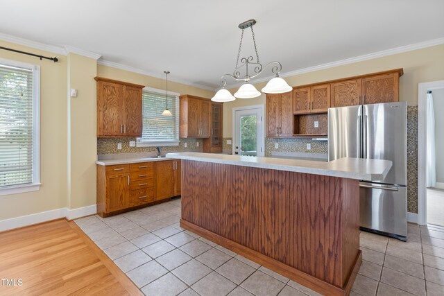 207 N Hopkins Ave, Spring Hope, NC 27882 - kitchen featuring freestanding refrigerator, light countertops, a sink, backsplash, and crown molding