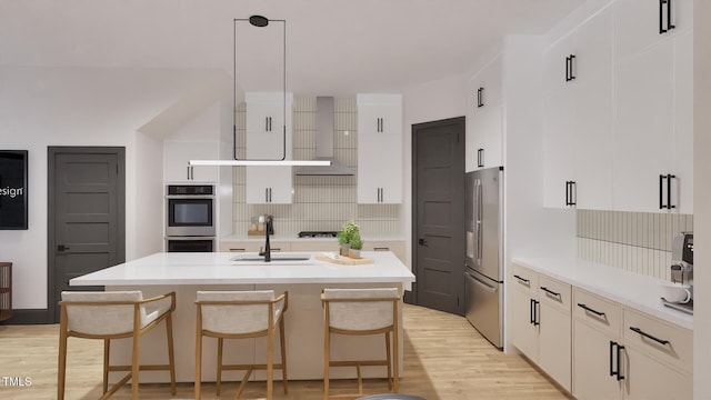 kitchen with a sink, appliances with stainless steel finishes, backsplash, and light wood-type flooring