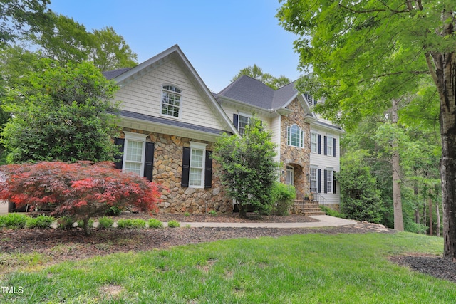 colonial house featuring stone siding and a front lawn