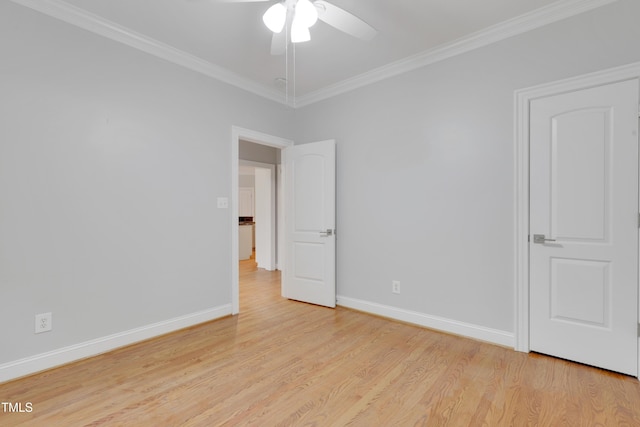 unfurnished room with crown molding, light wood-style flooring, a ceiling fan, and baseboards