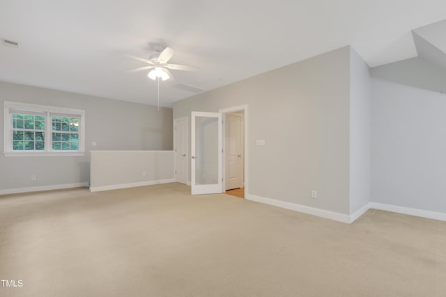 unfurnished room featuring ceiling fan, light colored carpet, and baseboards