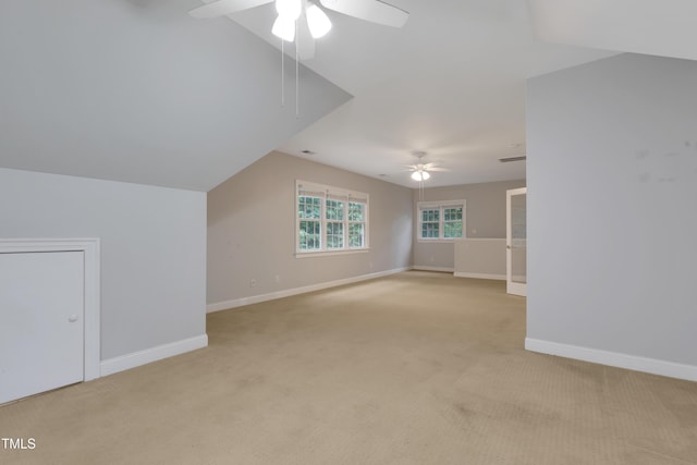 bonus room with ceiling fan, light colored carpet, and baseboards