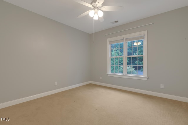 empty room featuring light carpet, baseboards, and a ceiling fan