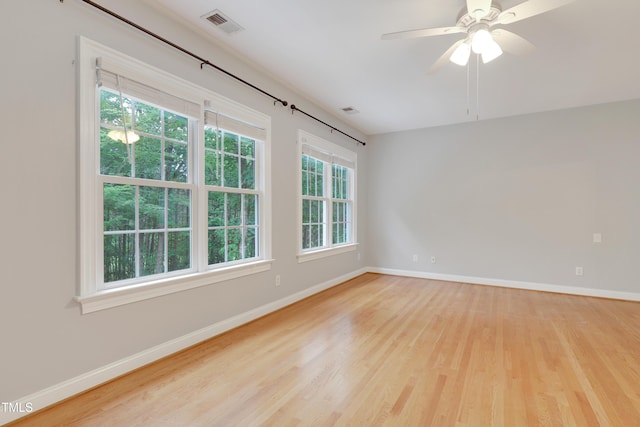 empty room featuring wood finished floors, baseboards, and ceiling fan